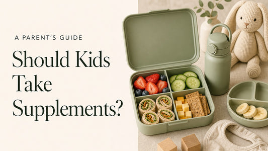 A sage-green children’s lunchbox filled with fruit, vegetables, wrap pinwheels and crackers beside a water bottle, knit bunny, bib and wooden blocks. Headline: Should Kids Take Supplements?